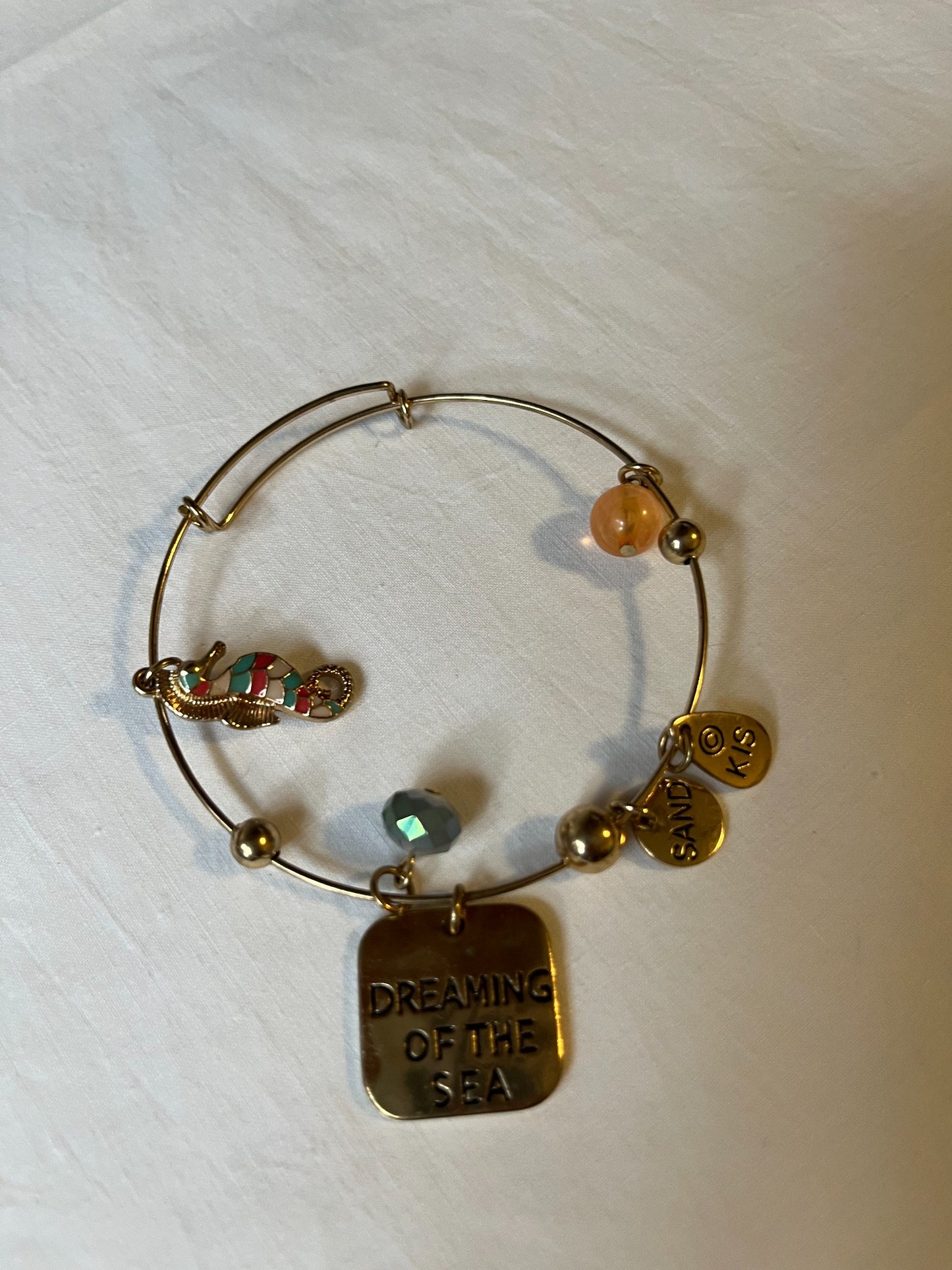Gold-tone seaside charm bangle bracelet detail