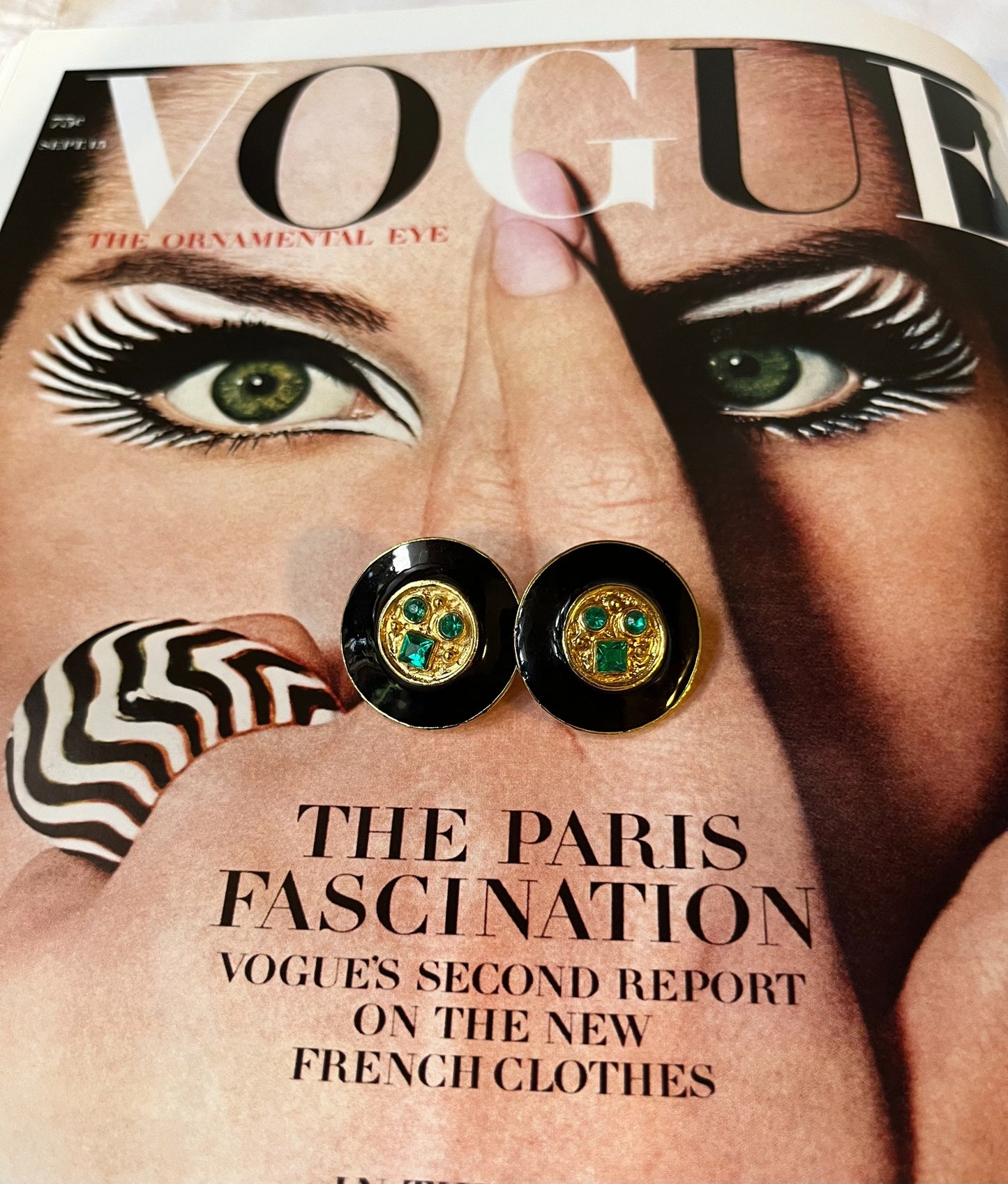 Close-up vintage black enamel and green rhinestone round earrings