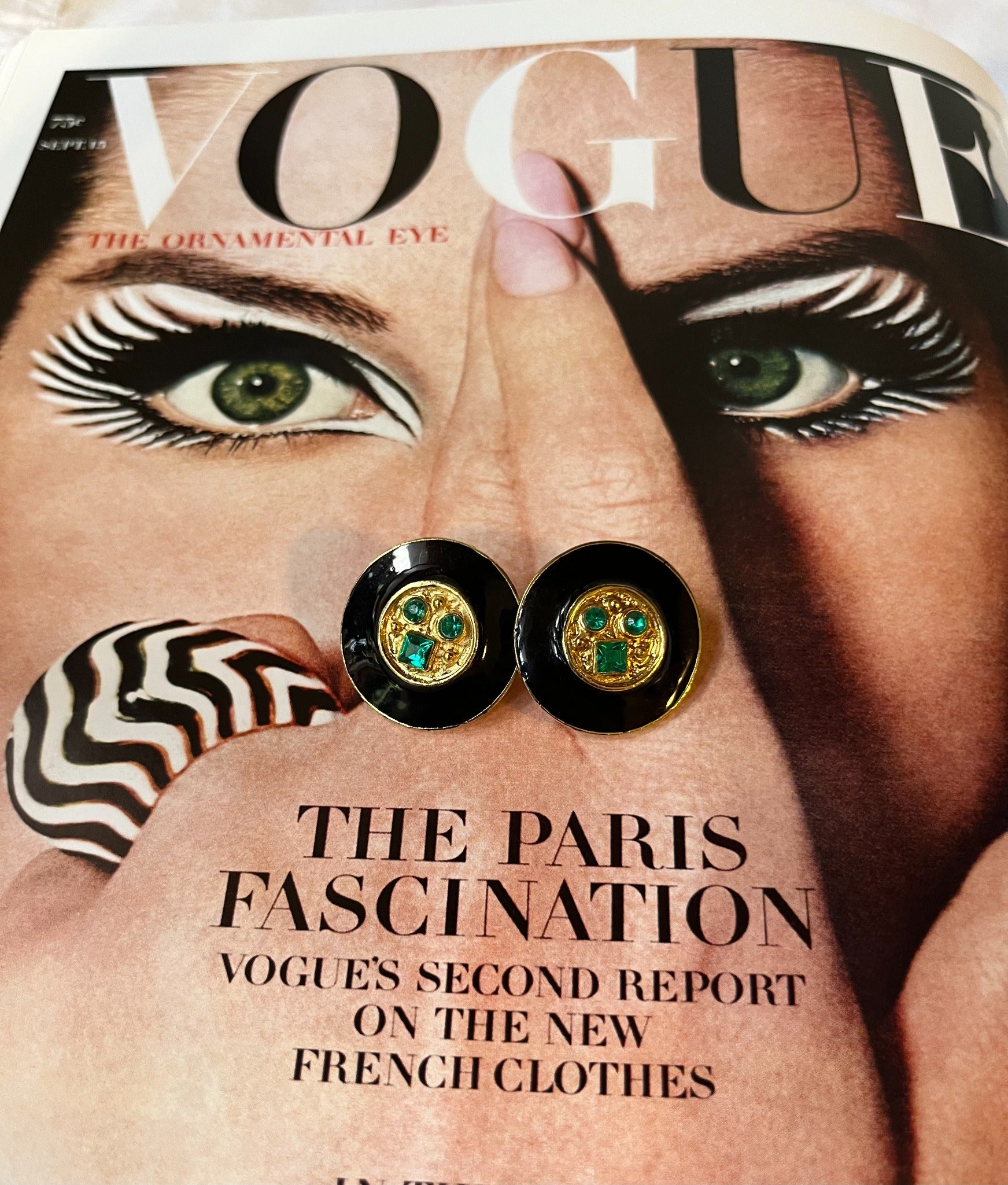 Close-up vintage black enamel and green rhinestone round earrings