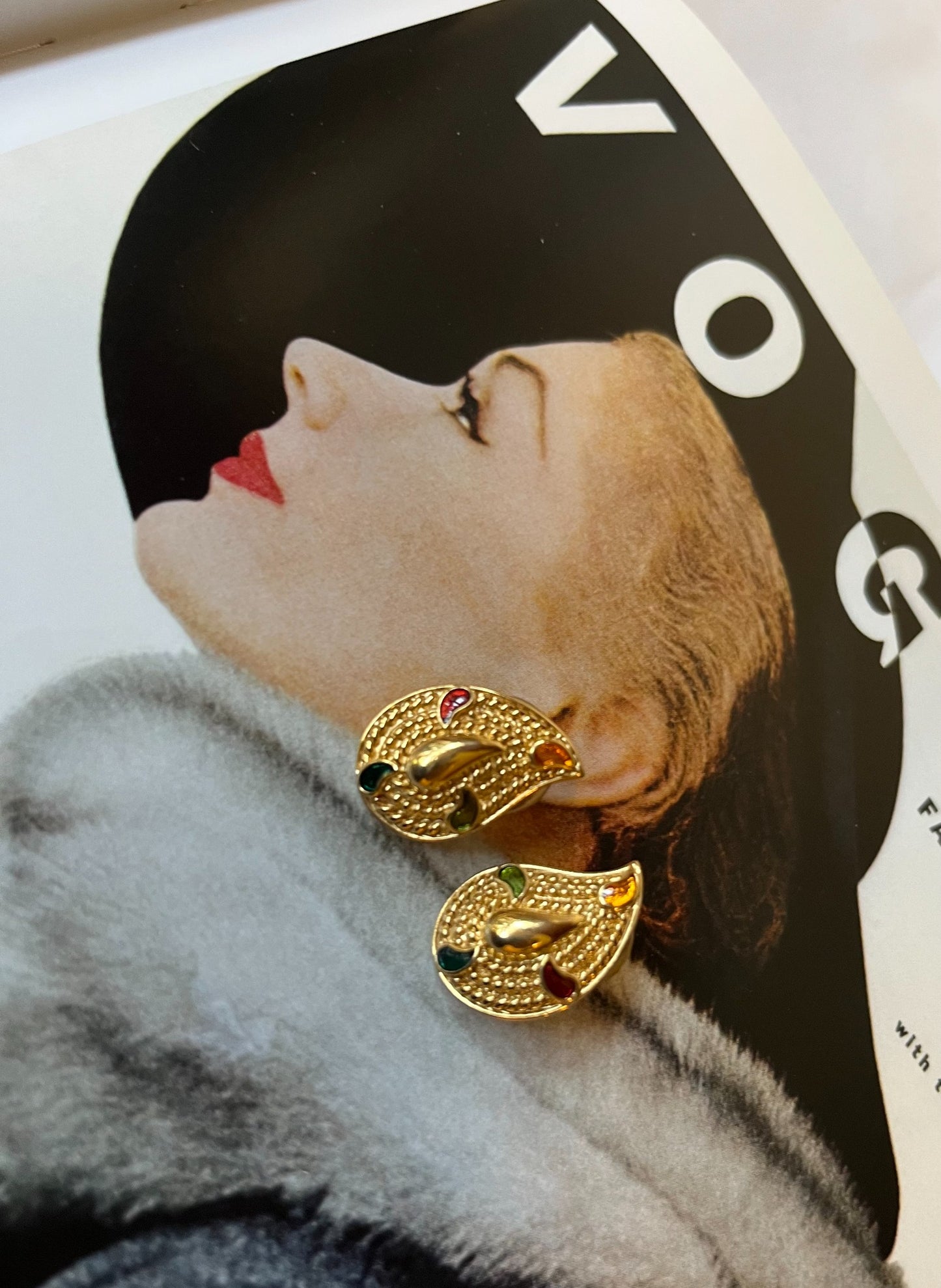 Close-up vintage gold-tone paisley earrings with multicolor enamel accents