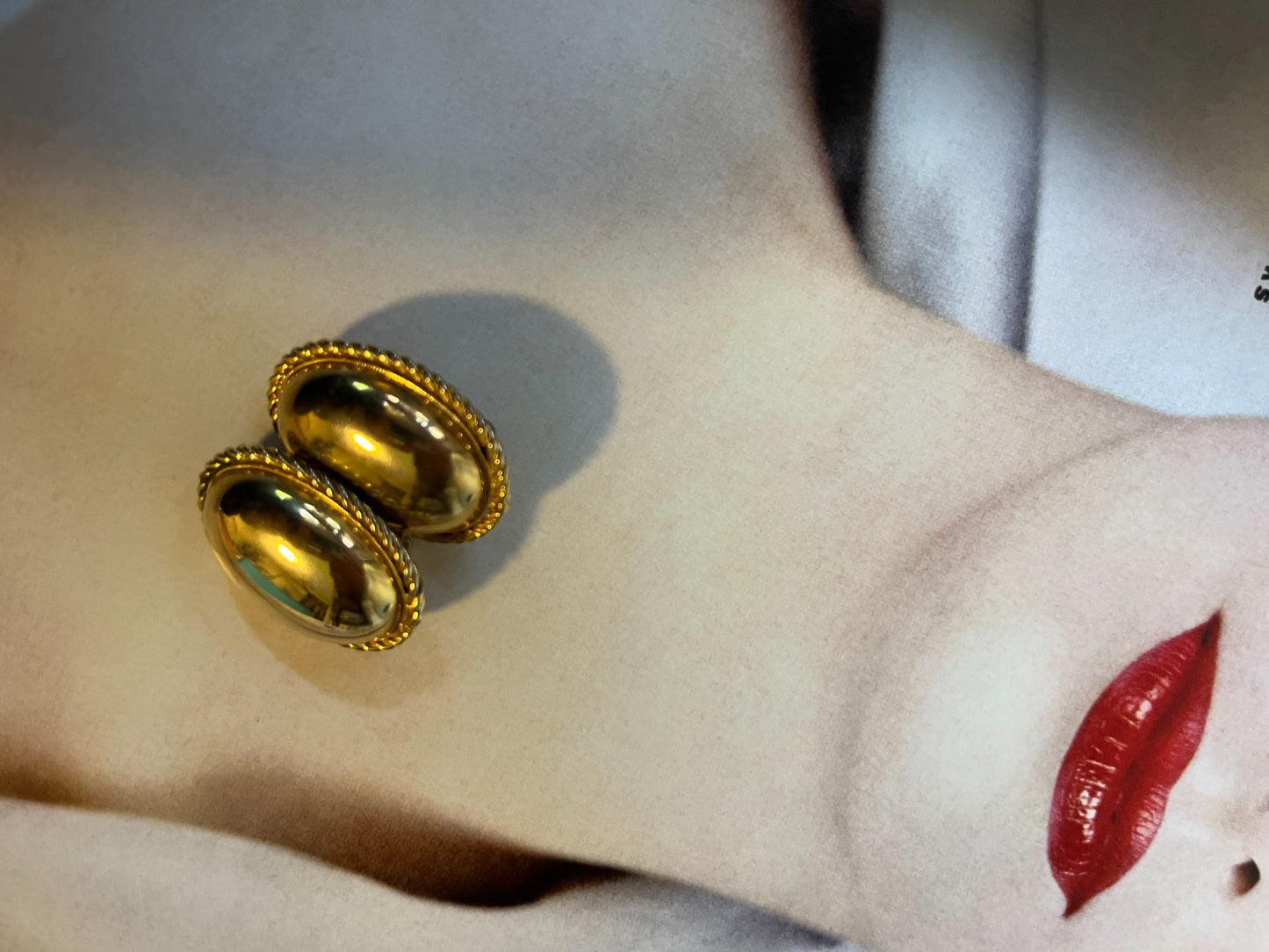 Close-up vintage polished gold-tone oval dome earrings with rope border