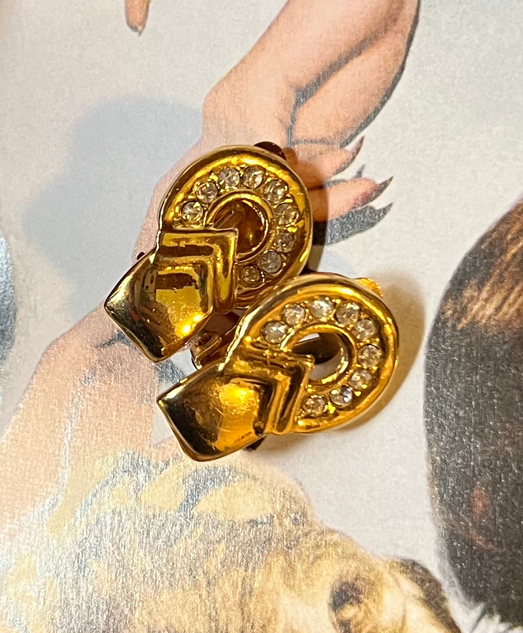 Close-up vintage gold-tone geometric earrings with clear rhinestones