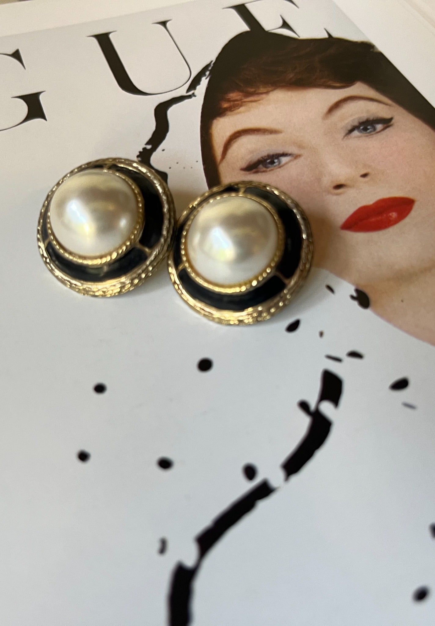 Close-up vintage faux pearl and black enamel round earrings