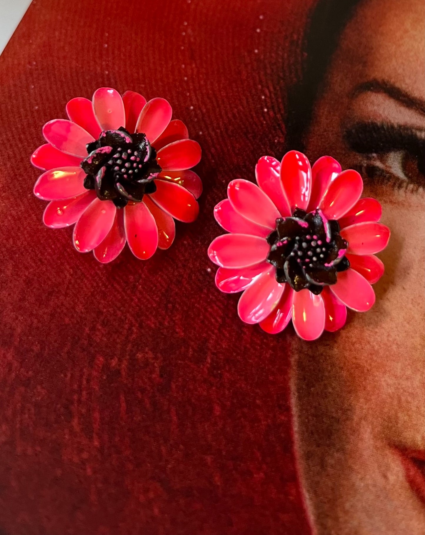 Close-up vintage bright pink flower statement earrings with dark centers