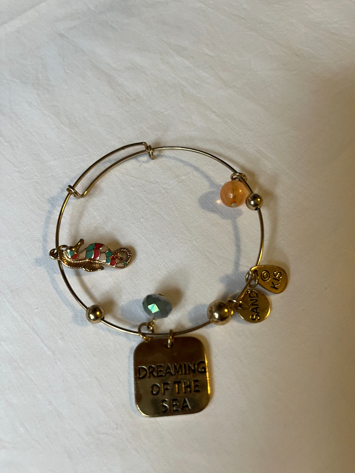 Gold-tone seaside charm bangle bracelet detail